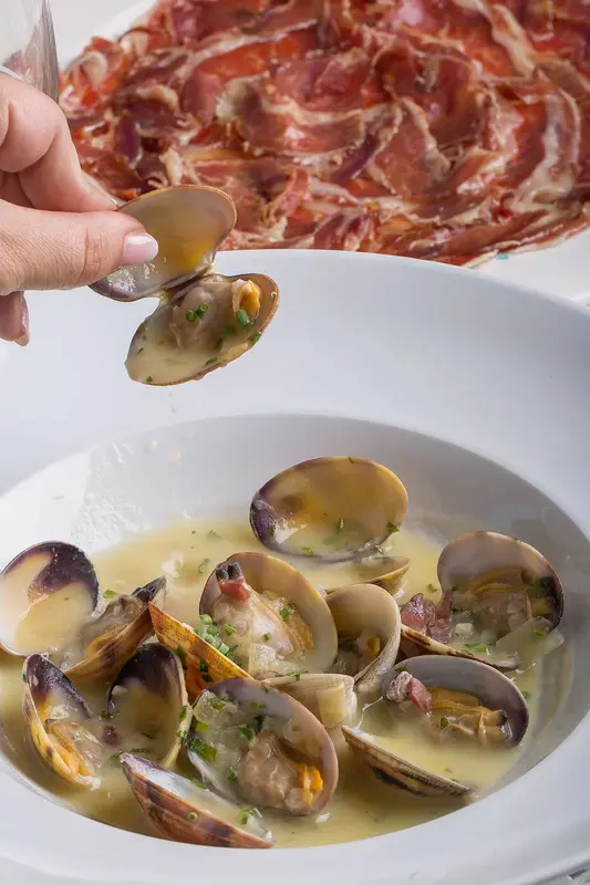 Almejas gallegas al vino blanco con virutas de jamón ibérico ((300 gr)