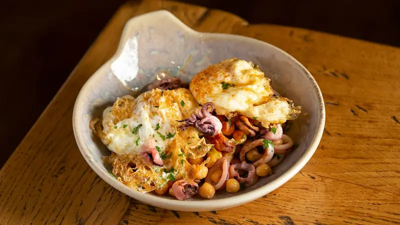 Huevos fritos sobre garbanzos de “l’anoia” y chipirones salteados