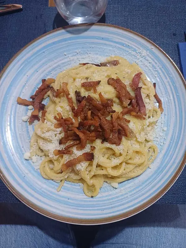 Spaghetti carbonara — servido en rueda de pecorino