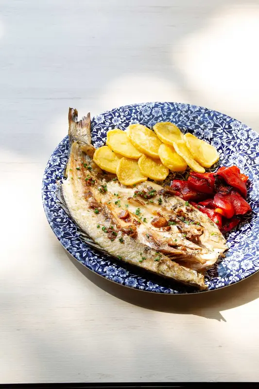 Lubina abierta a la brasa con refrito de ajos, patata y pimientos - precio para 2 personas