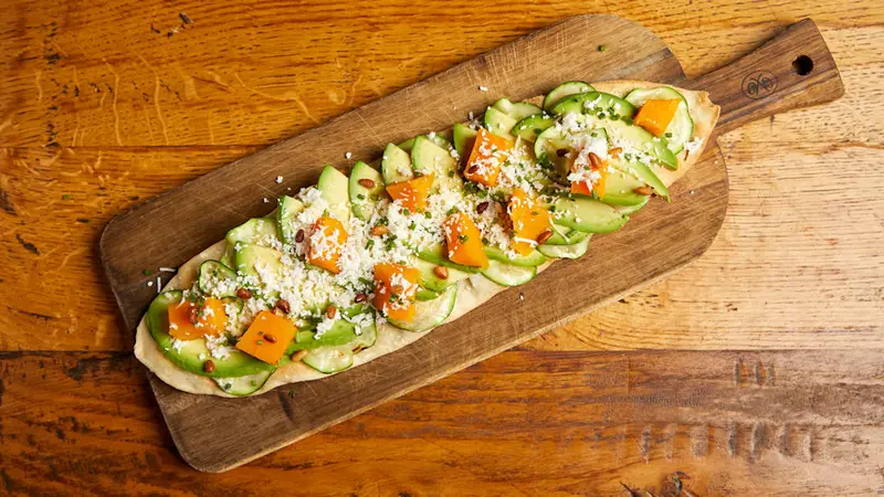 De aguacate, calabaza, calabacín, queso de cabra y piñones tostados