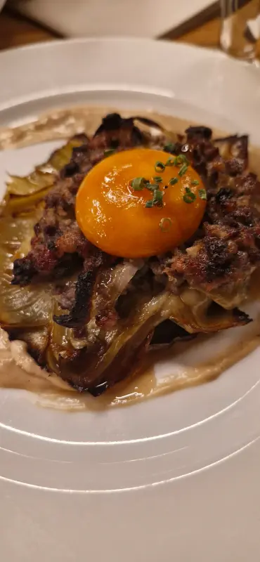 Flor de alcachofa con butifarra perol, yema y foie