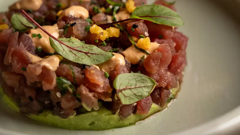 Tartar de atún con sésamo, aguacate cremoso, mango y emulsión de kimchi, con tostadas 