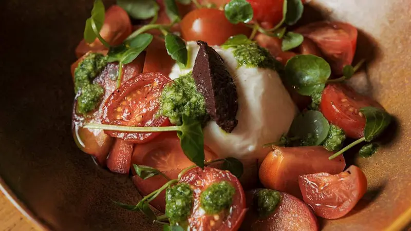 Burrata de puglia con tomate fresco, olivas kalamata y pesto de albahaca
