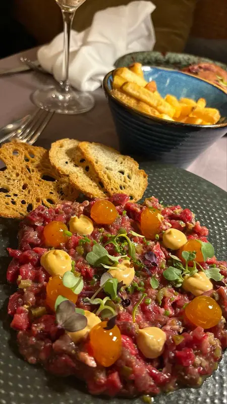 Steak tartar de ternera madurada con yema confitada, mostaza japonesa y emulsión de chipotle ahumado, con tostadas y patatas fritas 