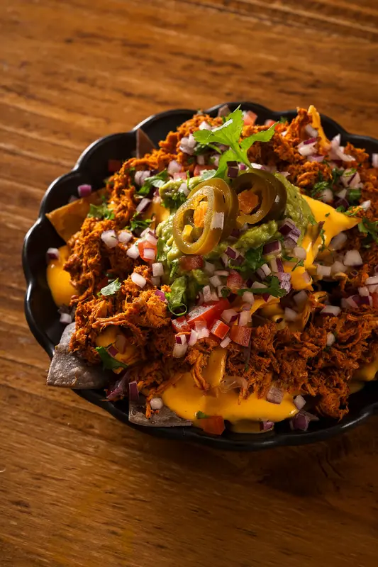 Nachos con guacamole, cochinita pibil & crema de queso cheddar (1/2 ración)